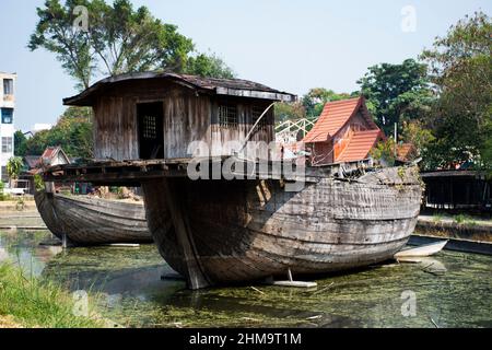 Broken ruins wood chinese sailing ship or damage wooden antique junk boat china style in pond of garden park for thai people travel visit in Wat Samph Stock Photo