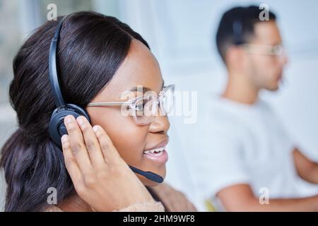 We should have been working together ages ago. Shot of male and female team members sitting at their desks in their call center office. Stock Photo