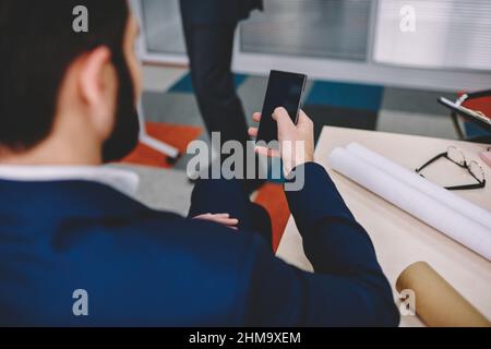 Businessman using smartphone in office Stock Photo