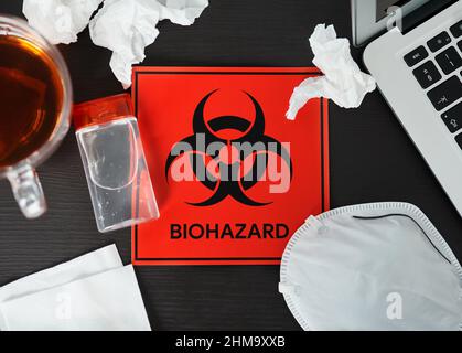 Stay home to prevent your colleagues from getting infected. Shot of a biohazard sign on a workstation. Stock Photo