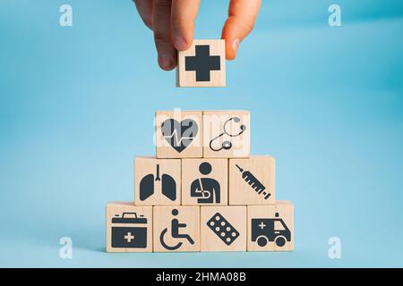 Hand arranging wood block stacking with the healthcare medical icon. Health insurance - health concept