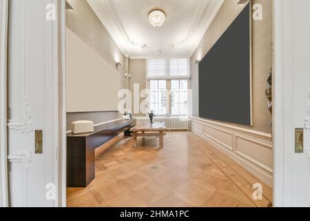 Doorway to room with bench for historic museum visitors and empty boards hanging on walls Stock Photo