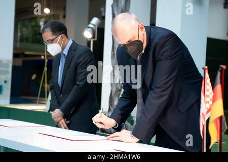 Bremen, Germany. 08th Feb, 2022. Andreas Bovenschulte (SPD, r) Mayor of Bremen, and Darion Akins, Consul General of the USA in Hamburg, sign the handover documents. In a ceremony, the human remains from the Übersee Museum's collection are handed over to a delegation from the state of Hawai'i. The iwi kupuna (ancestral bones) had come into the museum's colonial history collection in the 19th and 20th centuries. The State of Hawai'i had requested the return of eight skulls in 2019. Credit: Sina Schuldt/dpa/Alamy Live News Stock Photo