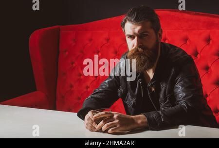 Elegant and stylish man in classical wear with wiskey. Cheerful bearded sman is drinking expensive whisky. Old traditional whiskey drink - gentlemans Stock Photo