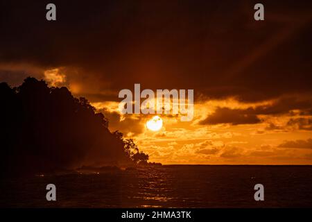 Amazing scenery of colorful sky in sundown over rippling sea with forest on coast in evening in Costa Rica Stock Photo