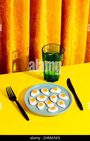 From above of plate with jelly eggs and fork placed on yellow table Stock Photo