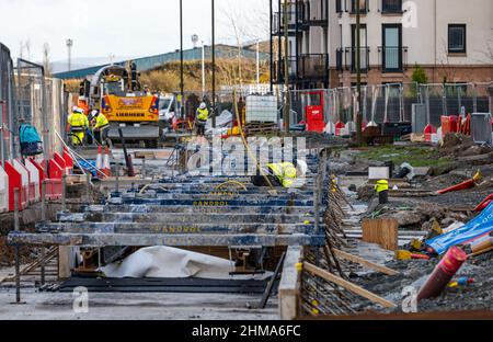 Leith, Edinburgh, Scotland, United Kingdom, 8th February 2022. Trams to Newhaven construction: As the major project approaches its final year, with work due on schedule and due to be completed in Spring 2023 within its £207.3m budget, numerous roads are closed to traffic in Leith. More than 60% of track has now been laid (2.8km) & 85% of the utility diversions have been carried out. Pictured: the tram track being constructed on Ocean Drive Stock Photo
