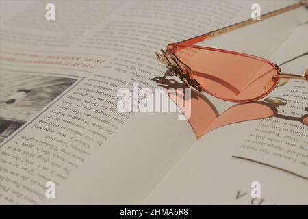Glasses on top of a book, forming a heart shape. Stock Photo