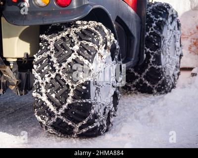Wheels with snow chains on the vehicle for clearing snowy roads - snow plow. Stock Photo