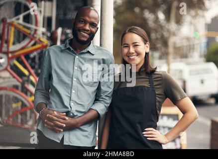 Were professionals in the industry. Shot of two young business owners standing outside their bicycle shop during the day. Stock Photo