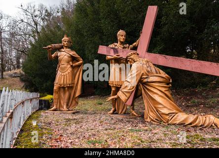 Lourdes, France - January 5, 2022: Way of the cross of Lourdes - third station: Jesus falls a first time under the cross Stock Photo