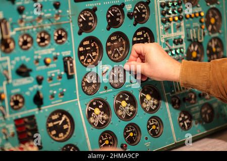 The flight engineer switches tumbler in the airliner Stock Photo