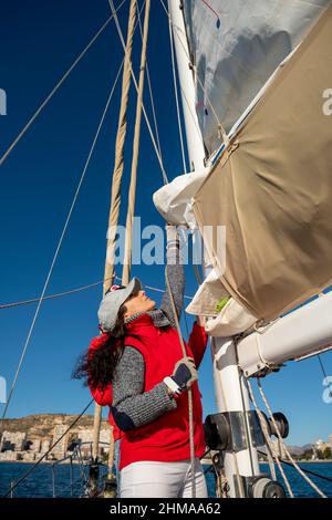 Adult Woman Pulling Rope on Sailboat , Alicante, Costa Blanca, Spain Stock Photo