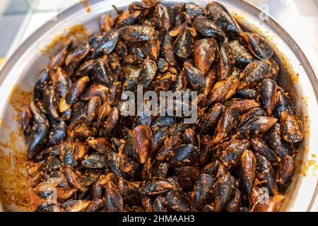 Bowl of Midye dolma stuffed mussels, a traditional turkish street food for sale in Istanbul, Turkey Stock Photo