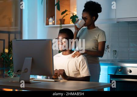 Wife support husband web programmer in creating app or website design for freelance project at home Stock Photo