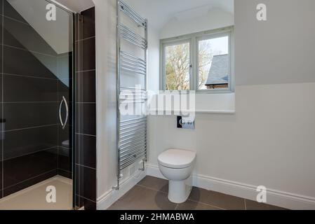 Great Wilbraham, Cambridgeshire, England - March 27 2017: Brand new shower room within vacant just finished property with tiled cubicle and white pain Stock Photo