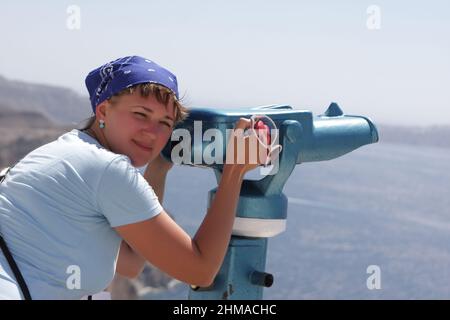 Woman is posing with telescope, santorini, greece Stock Photo