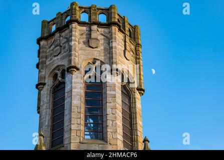 Hexagonal church tower with a half moon visible in bright blue sky, Leith, Edinburgh, Scotland, UK Stock Photo