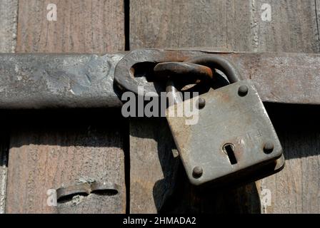 Wada or Vada  Maharashtra, India- Asia, Feb, 2009 : Rusted old padlock on latch. Vintage lock protecting a wooden door. Stock Photo