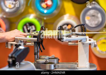 manual stringing of a badminton racket in service Stock Photo