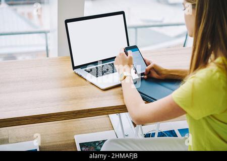 Anonymous female freelancer messaging while working on computer in cafe Stock Photo
