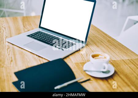 Laptop and cup of coffee on table Stock Photo