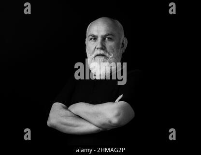 Senior man crossed arms on black. Portrait. Stock Photo