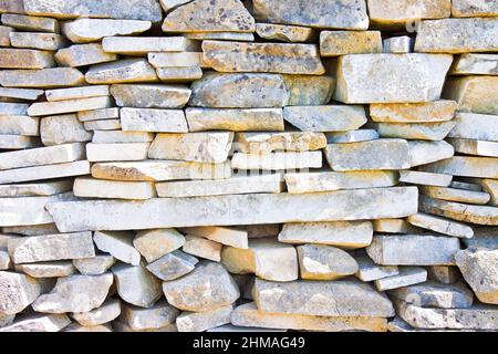 Stone wall built with blocks and marble slabs simply placed over one another Stock Photo