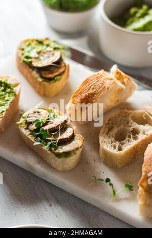 Baguette with guacamole, champignons mushrooms and micro green on white plate. Brunch ideas. Vegan protein source. healthy food. clean eating. Stock Photo