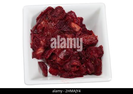 Heap of dried strawberries in white squaer bowl. It isolated over white background. Close-up. Stock Photo