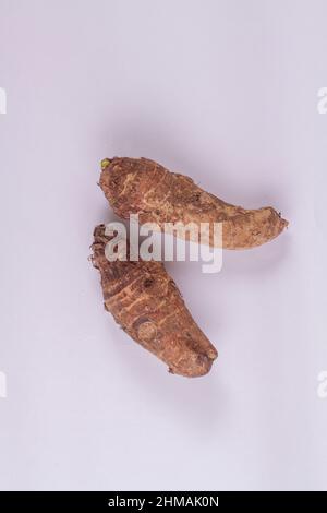 assava tubers fresh on isolated white, pile cassava manioc in top view, yucca root for flour products, raw materials for tapioca starch industry, tube Stock Photo