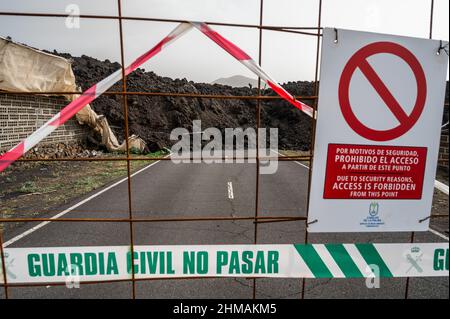 Lava of the Cumbre Vieja volcano passes through a road on its way towards the sea. Many roads have been blocked by volcanic lava during the eruption Stock Photo