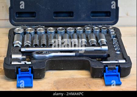 black box of socket wrenches on wooden workbench Stock Photo