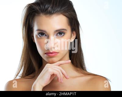 Shes a portrait of natural beauty. Studio portrait of a beautiful young woman posing against a blue background. Stock Photo
