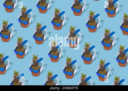 Creative trendy summer pattern with pineapple wearing sunglasses and headphones on bright blue background. Creative scene of fun, party, fashion, tren Stock Photo