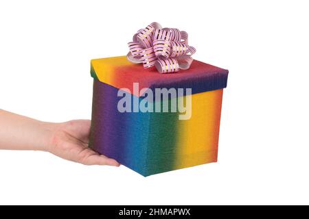 Colorful gift box with golden bow in hand. Isolated over white background. Close-up. Stock Photo