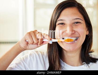 No one ever regrets brushing their teeth. Closeup shot of a beautiful young woman brushing her teeth. Stock Photo