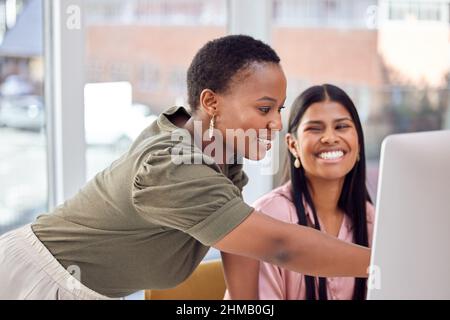 Shes always ready to help. Shot of a two businesswomen discussing something on a computer. Stock Photo