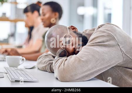 Dont sleep on your dreams. Shot of a young businessman sleeping at his desk in an office. Stock Photo