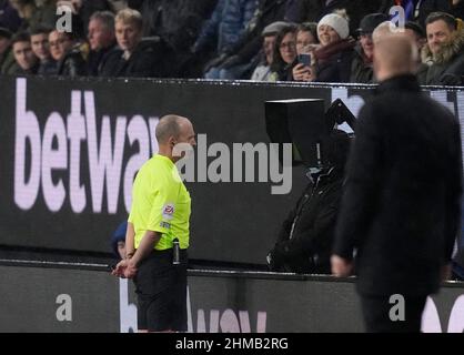 Burnley, England, 8th February 2022.   Referee Mike Dean looks at VAR before disallowing a goal from Raphael Varane of Manchester United during the Premier League match at Turf Moor, Burnley. Picture credit should read: Andrew Yates / Sportimage Stock Photo