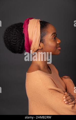 A close up portrait of a black woman with her hair tied back and wearing and hair band. Stock Photo
