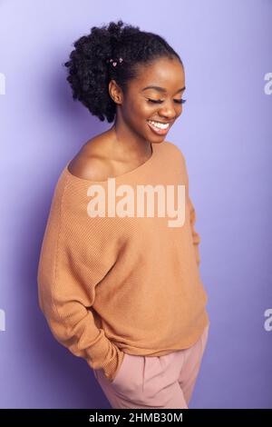 A pretty black woman looking relaxed with her hands in her pockets Stock Photo