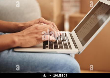 Looking for the perfect place to call home. Shot of an unrecognizable person using a laptop at home. Stock Photo