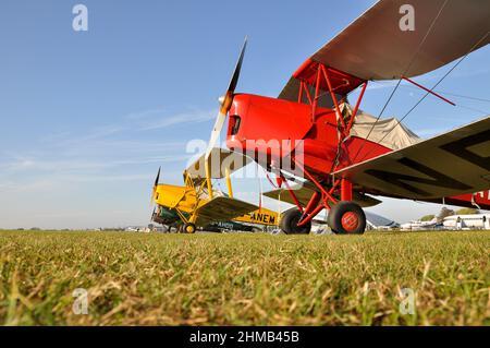 Tiger Moth biplanes sitting on the grass at Duxford airfield. de Havilland DH82 Tiger Moth plane. Vintage aircraft. Planes. Airplanes. Aviation Stock Photo