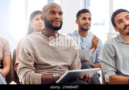 Im making a digital note of everything. Shot of a businessman sitting with his notebook during a presentation. Stock Photo