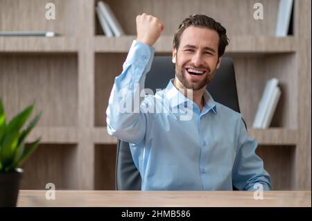 A manager in a blue shirt feeling joyful and happy Stock Photo