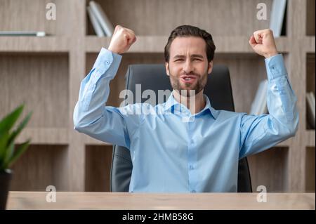 A manager in a blue shirt feeling joyful and happy Stock Photo