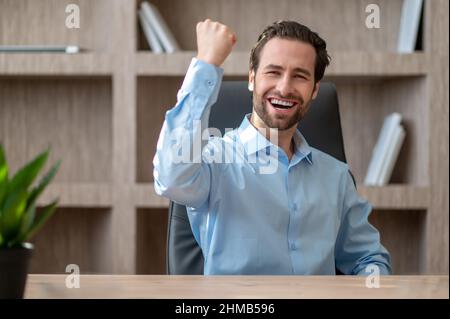 A manager in a blue shirt feeling joyful and happy Stock Photo