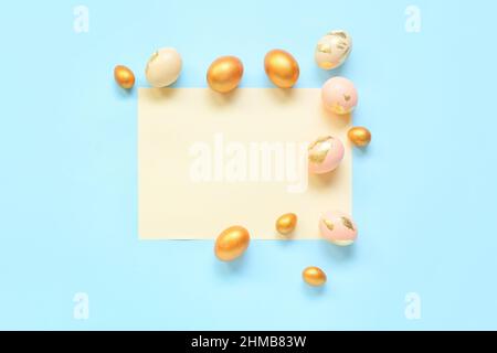 Sheet of paper and Easter eggs on blue background Stock Photo