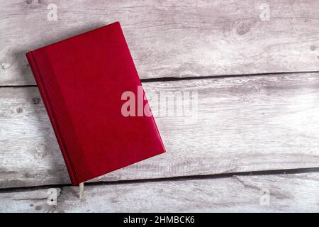 diary made of red leather on a wooden background Stock Photo